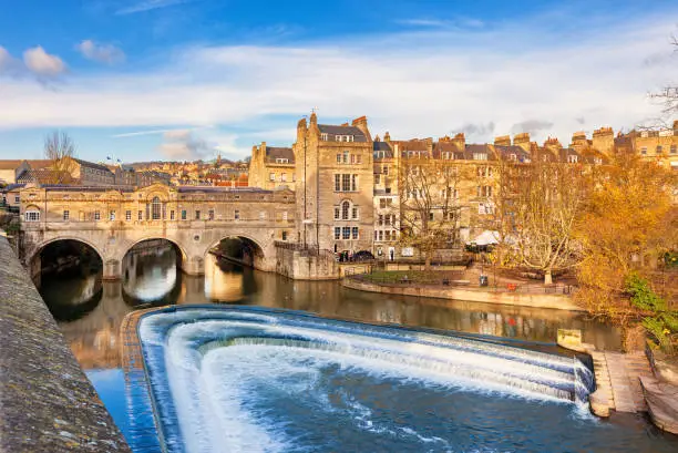 Stock photograph of Pulteney Bridge above River Avon in Bath, England, United Kingdom on a sunny day.