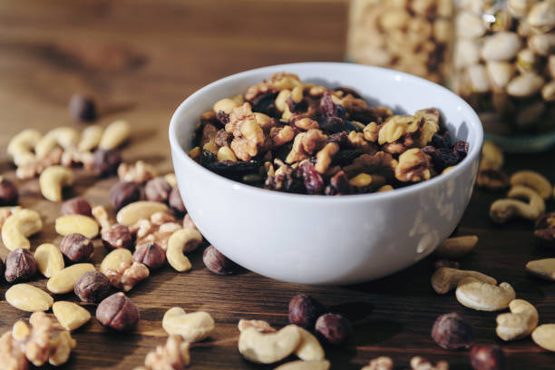 istock white bowl with organic mixed nuts on wooden table 1186193322