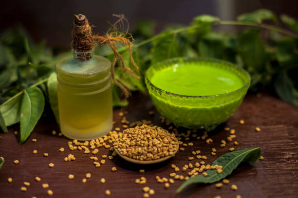 istock All scalp related problems solution lotion or shampoo in a glass bowl consisting of some neem leaves, fenugreek seeds and olive oil. Shot of fresh leaves of Neem tree,fenugreek seeds,pack,& olive oil. 1186197562