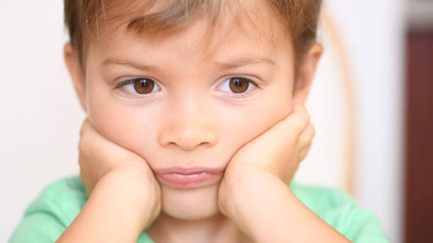 istock Sad bored little child boy close up 1186200543