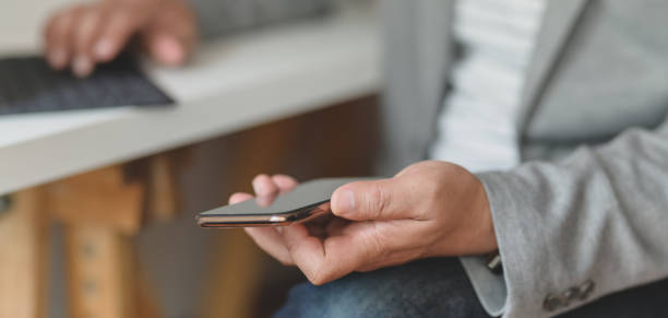 istock Close-up view of businessman using smartphone in relax sitting movement 1186211969