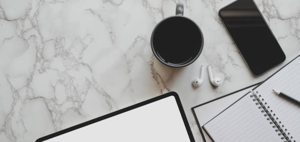 istock Top view of modern workspace with tablet and office supplies on marble table 1186211977