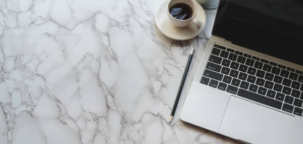 istock Top view of modern stylish workplace with laptop computer and coffee cup on marble table 1186212008