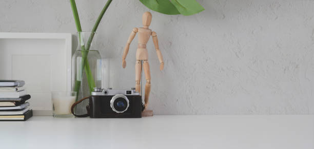 istock Minimal workplace with mock up frame, camera and office supplies on white table 1186212057