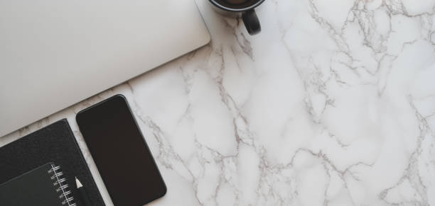 istock Top view of modern workplace with laptop computer and office supplies on marble table 1186212091