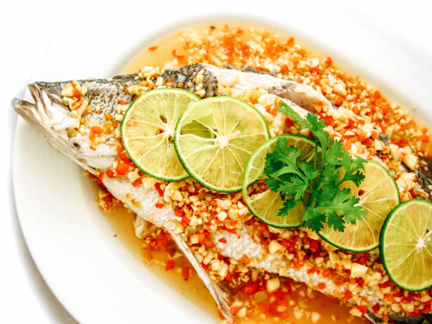 pesce al vapore con limone, cibo tailandese al ristorante - edible mushroom portion chopped freshness foto e immagini stock