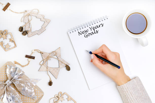 istock Young woman is writing goals on notebook, new year resolutions concept. 1186222431