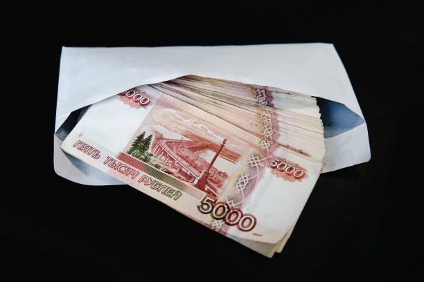 istock Money in white paper envelope. Ruble bribe in an envelope on black background. 1186225813