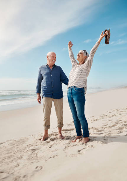 Look at all this life to enjoy! Shot of a senior couple having a fun day at the beach carefree senior stock pictures, royalty-free photos & images