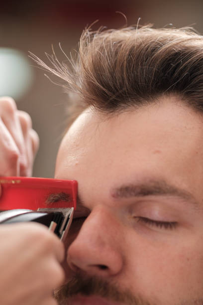 istock man with a beard cut eyebrows. close-up. barber haircut 1186245513
