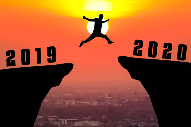 istock Silhouette young man jumping from 2019 to 2020 year 1186246918