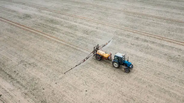 tractor treats field with pesticides top view