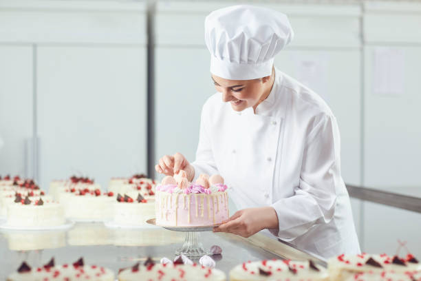 istock Confectioner is holding a cake in her hand in the bakery. 1186248292