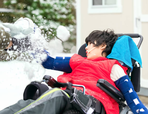 istock Disabled boy in wheelchair playing with snow in winter 1186253720