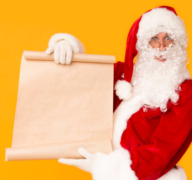 istock Santa holding big cardboard wish list with copy space for text 1186255651