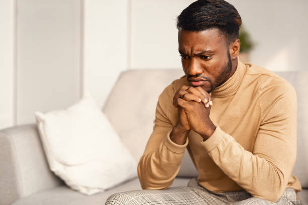 istock Unhappy Black Man Thinking Sitting On Couch At Home 1186255992
