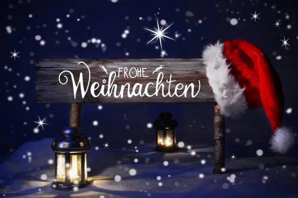 Sign With German Calligraphy Frohe Weihnachten Means Merry Christmas. Peaceful Christmas Night With Snow And Lamp.