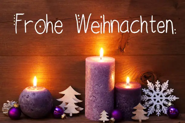German Calligraphy Frohe Weihnachten Means Merry Christmas. Purple Romantic Candle Light With Christmas Decoration. Brown Wooden Background