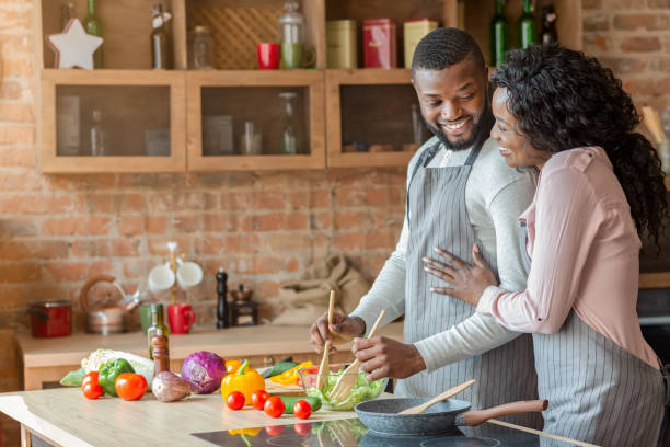 istock Thankful african lady hugging her husband, cooking together 1186257794