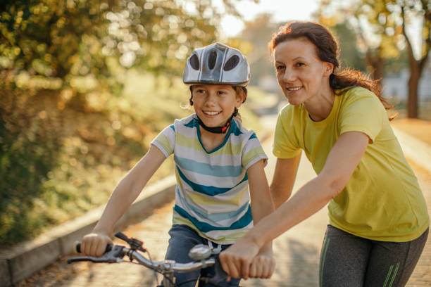 istock Happy boy learning to ride a bicycle in park at sunset 1186263115