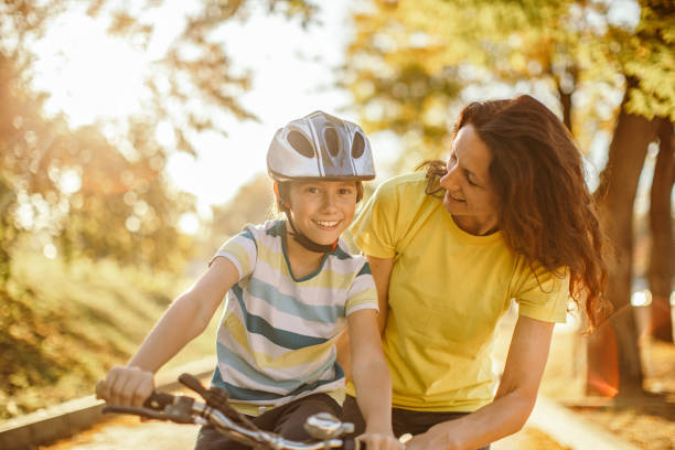 istock Happy boy learning to ride a bicycle in park at sunset 1186263142