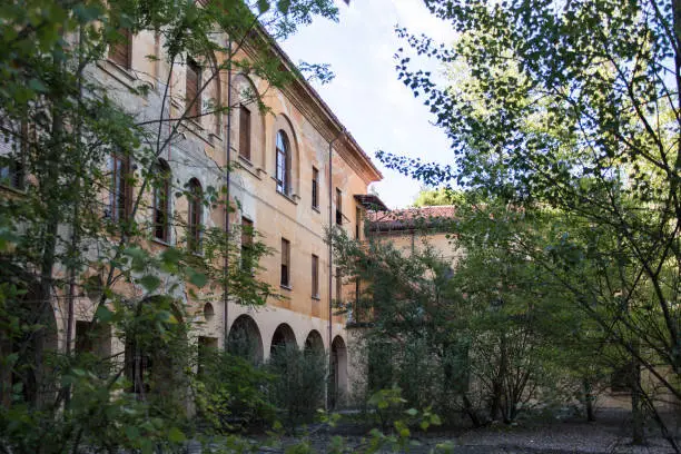 Photo of An abandoned seminary surrounded by vegetation