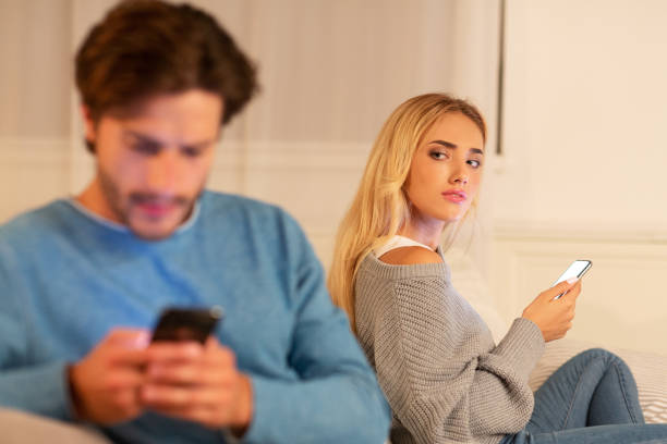 istock Wife Watching Husband Texting On Phone Suspecting Infidelity Sitting Indoor 1186271157