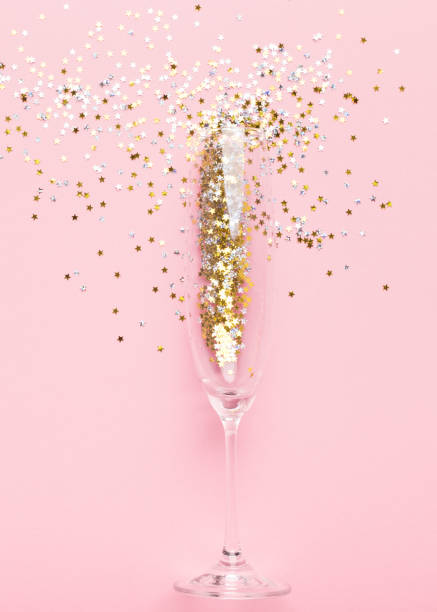 istock Champagne glass with gold tinsel on pink 1186271972