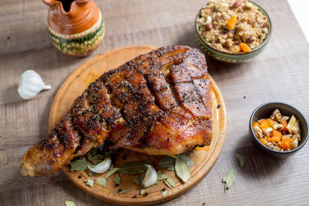 roast pork meat but with a bone on a wooden board stock photo