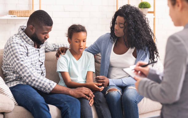 niña negra y sus padres en la consulta del psicólogo - terapia fotografías e imágenes de stock