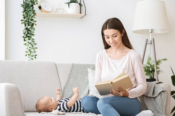 istock Caring mom reading book to her newborn child. 1186272501