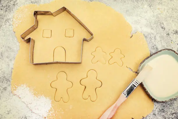 Cookie dough and cutter, family and house cutout, concept planning and baking a family