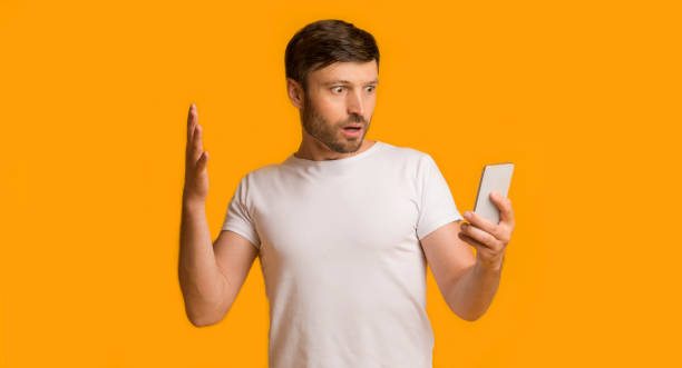 istock Shocked Man Looking At Smartphone Standing On Yellow Background, Panorama 1186274922