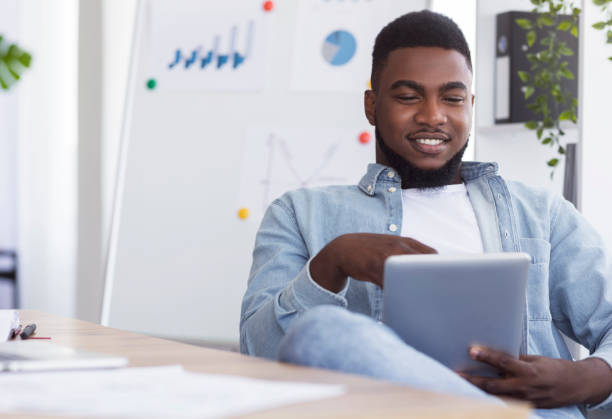 istock Relaxed african american employee using digital tab at workplace 1186275190