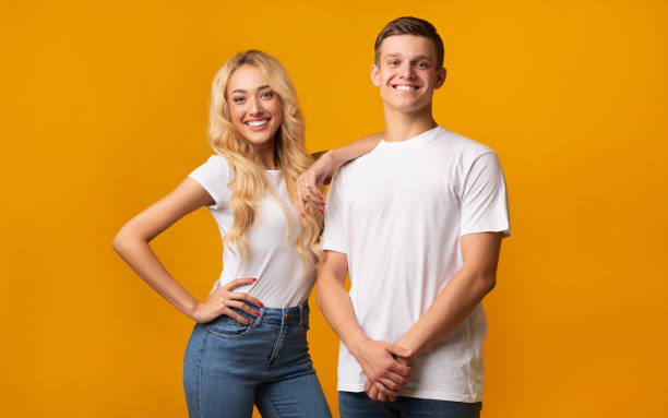 istock Smiling millennial couple posing over yellow background 1186278892