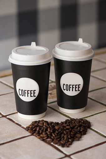 Coffee paper cups with coffee beans on the table