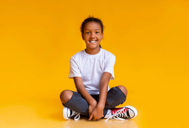 istock Cute black girl sitting on floor in studio and smiling 1186281070