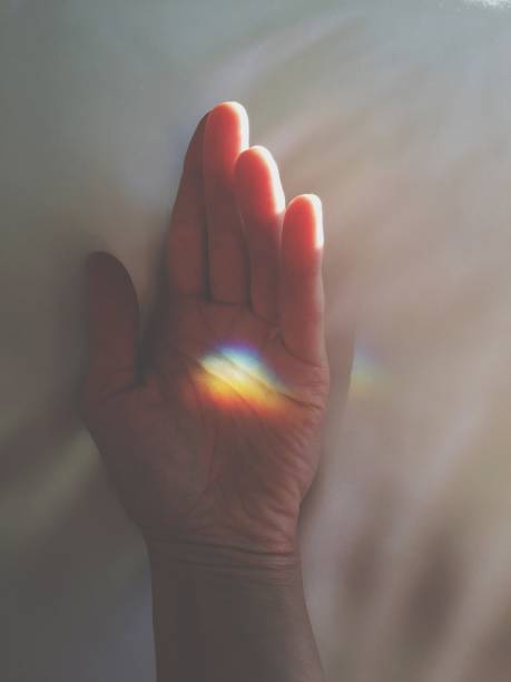 main poétique avec une lumière d'arc-en-ciel - poetic photos et images de collection