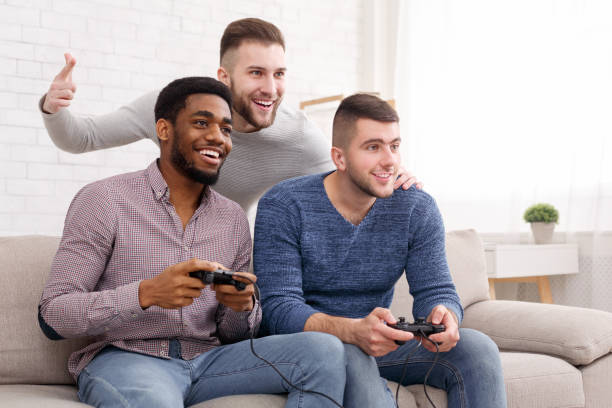 オンライン競争。ビデオゲームで競う友人 - gamer watching tv adult couple ストックフォトと画像