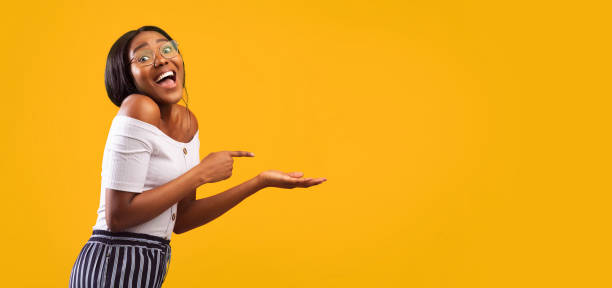 istock Girl Pointing Finger At Open Palm Standing, Studio Shot, Panorama 1186283935