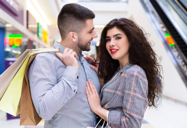 istock Young couple cuddling in mall after shopping 1186284971