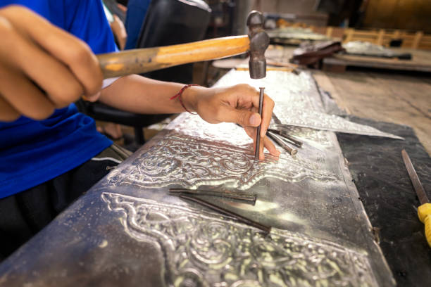 istock Silverware making. Thai craftman are making silverware. The original of the silver craftsmen on Wua Lai road, Chiang Mai. Thailand. 1186285639