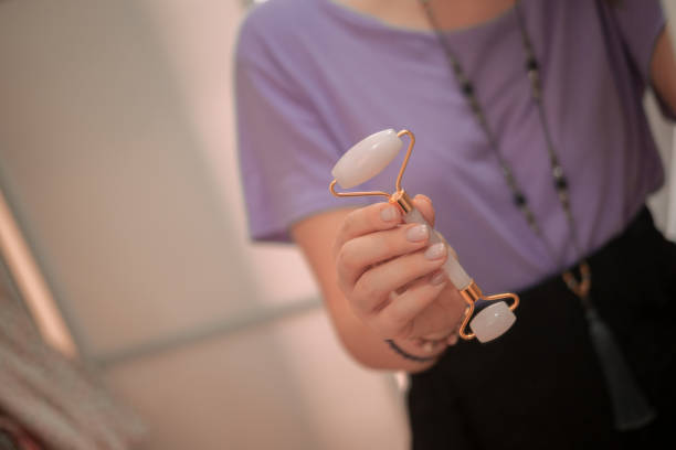 istock Woman holding rose quartz facial roller 1186288059