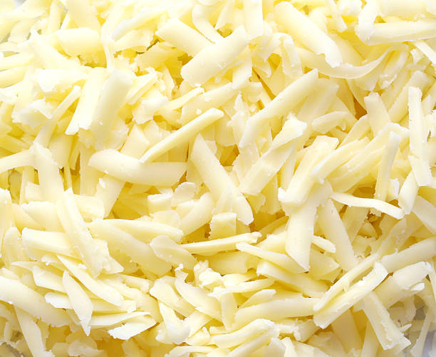 Close-up of white, grated cheddar cheese stock photo