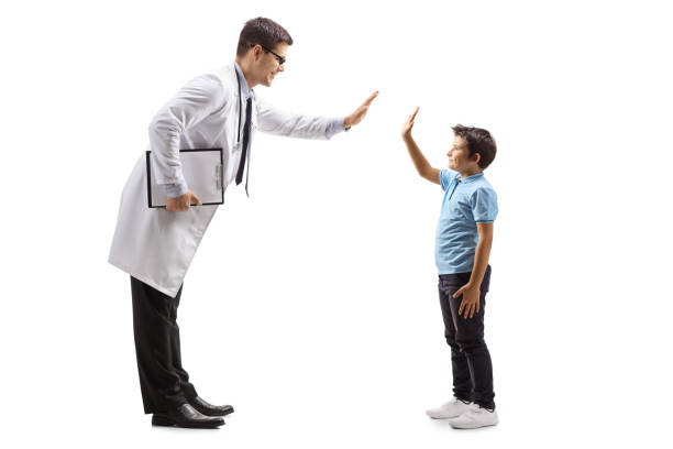 male doctor giving a high-five to a little boy - child little boys male caucasian imagens e fotografias de stock