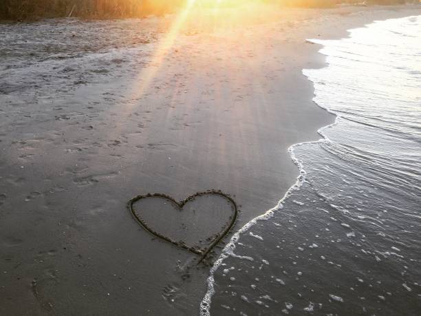istock Painted heart on sand. Vacation on sea 1186289732