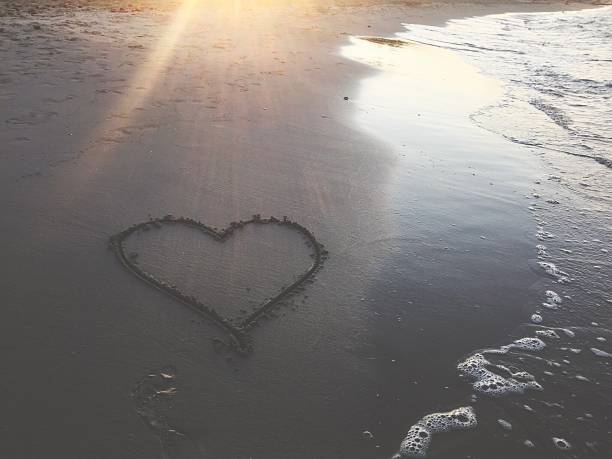 istock Painted heart on sand. Vacation on sea 1186290028