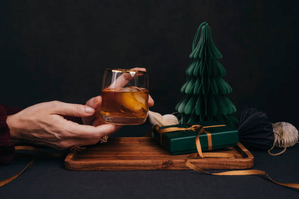 istock Woman drinking drink brandy whiskey or rum on ice Christmas feeling 1186290797