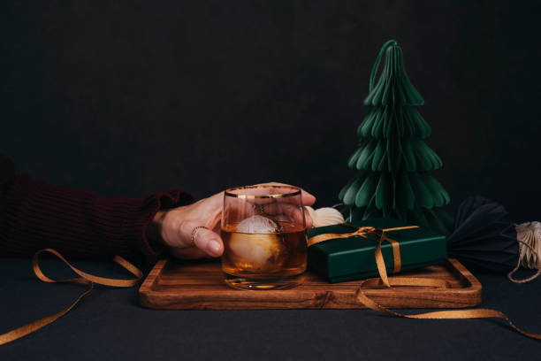Woman drinking drink brandy whiskey or rum on ice Christmas feeling stock photo