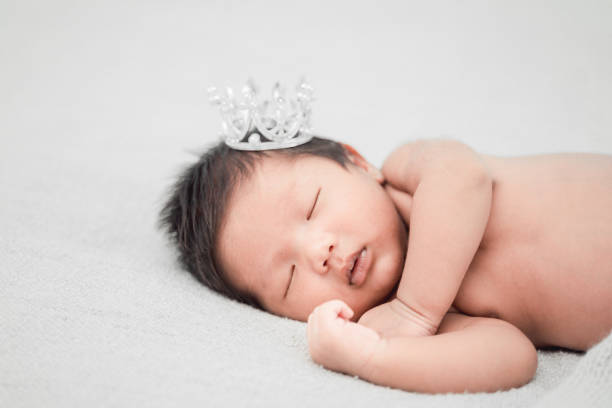 istock Newborn baby boy sleeping and wearing a silver crown. 1186291196